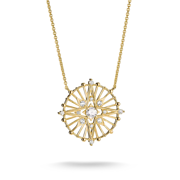 A gold pendant necklace featuring a circular sunburst design with clear gemstones, suspended from a delicate gold chain against a white background.