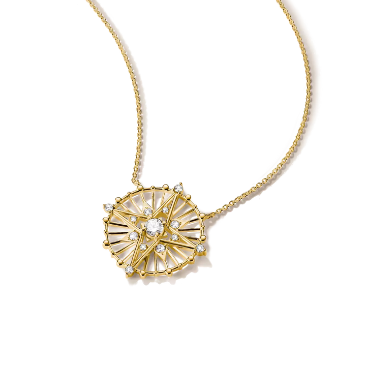 A gold necklace with a circular sunburst pendant featuring clear gemstones, shown on a clean white background.