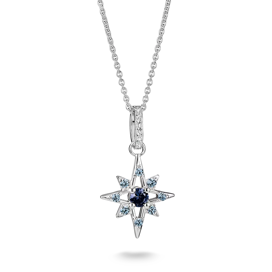 A silver-toned starburst pendant necklace featuring a central dark blue gemstone surrounded by small light blue and clear stones, suspended from a delicate silver chain on a white background.