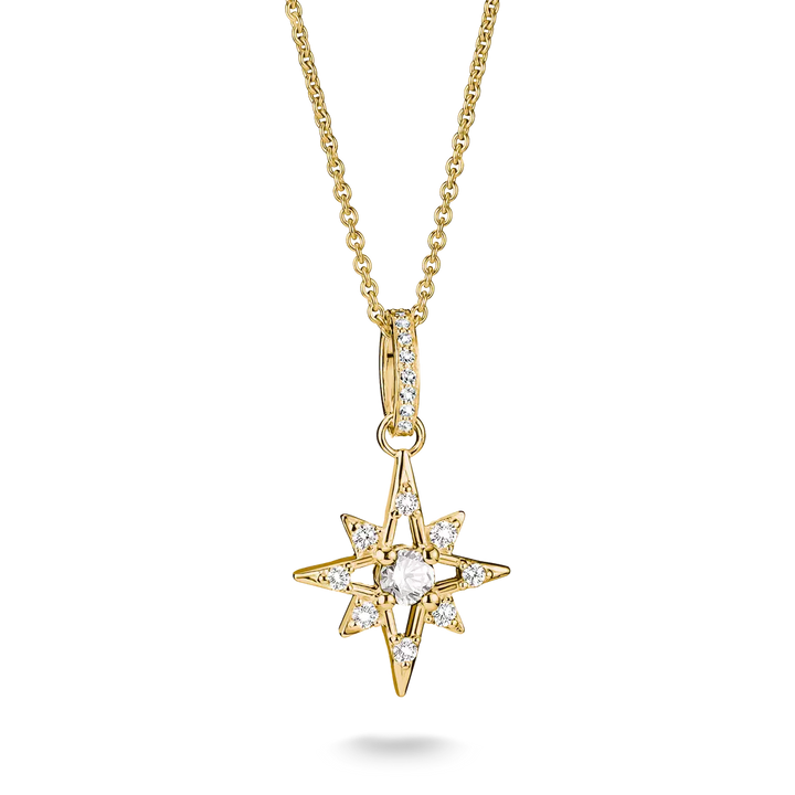 A gold starburst pendant necklace with a central round clear gemstone and smaller clear stones along the points, suspended from a gold chain on a white background.