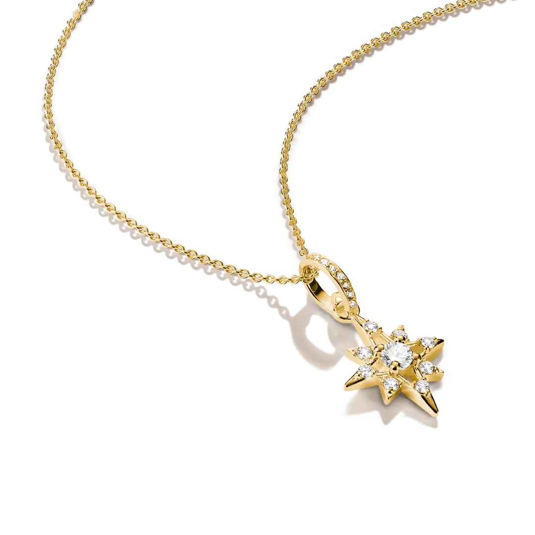 A gold necklace with a star-shaped pendant set with clear gemstones, displayed on a clean white background.