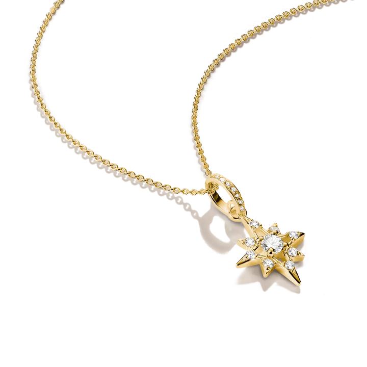 A gold necklace with a star-shaped pendant set with clear gemstones, displayed on a clean white background.