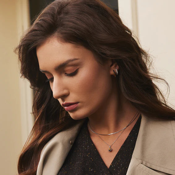 Woman wearing a beige coat with a neutral background