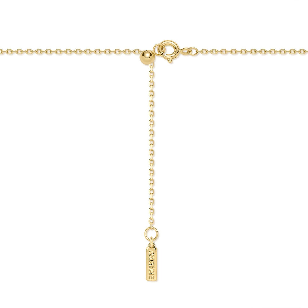 Gold necklace with a small tag on a white background