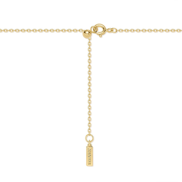 Gold necklace with a small tag on a white background