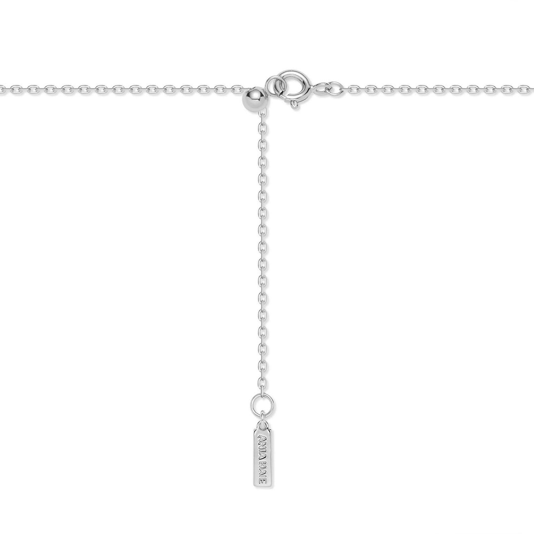 Silver necklace with a tag on a white background