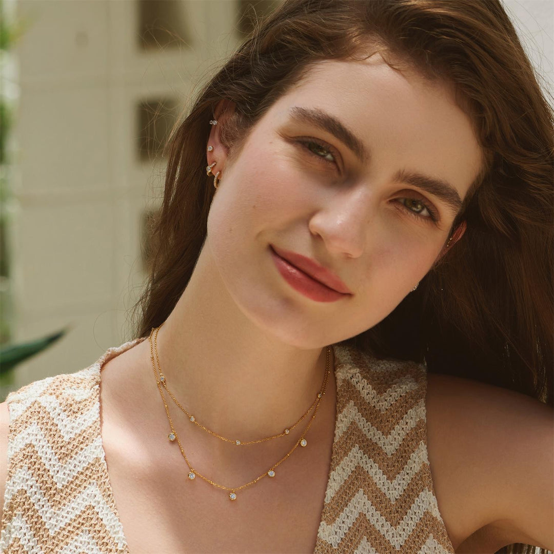 Woman wearing a gold necklace with a blurred background
