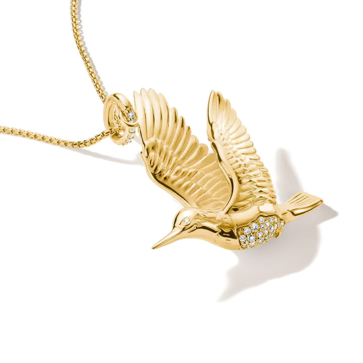 A gold pendant necklace featuring a flying bird pendant adorned with small clear stones, shown on a white background with a soft shadow.