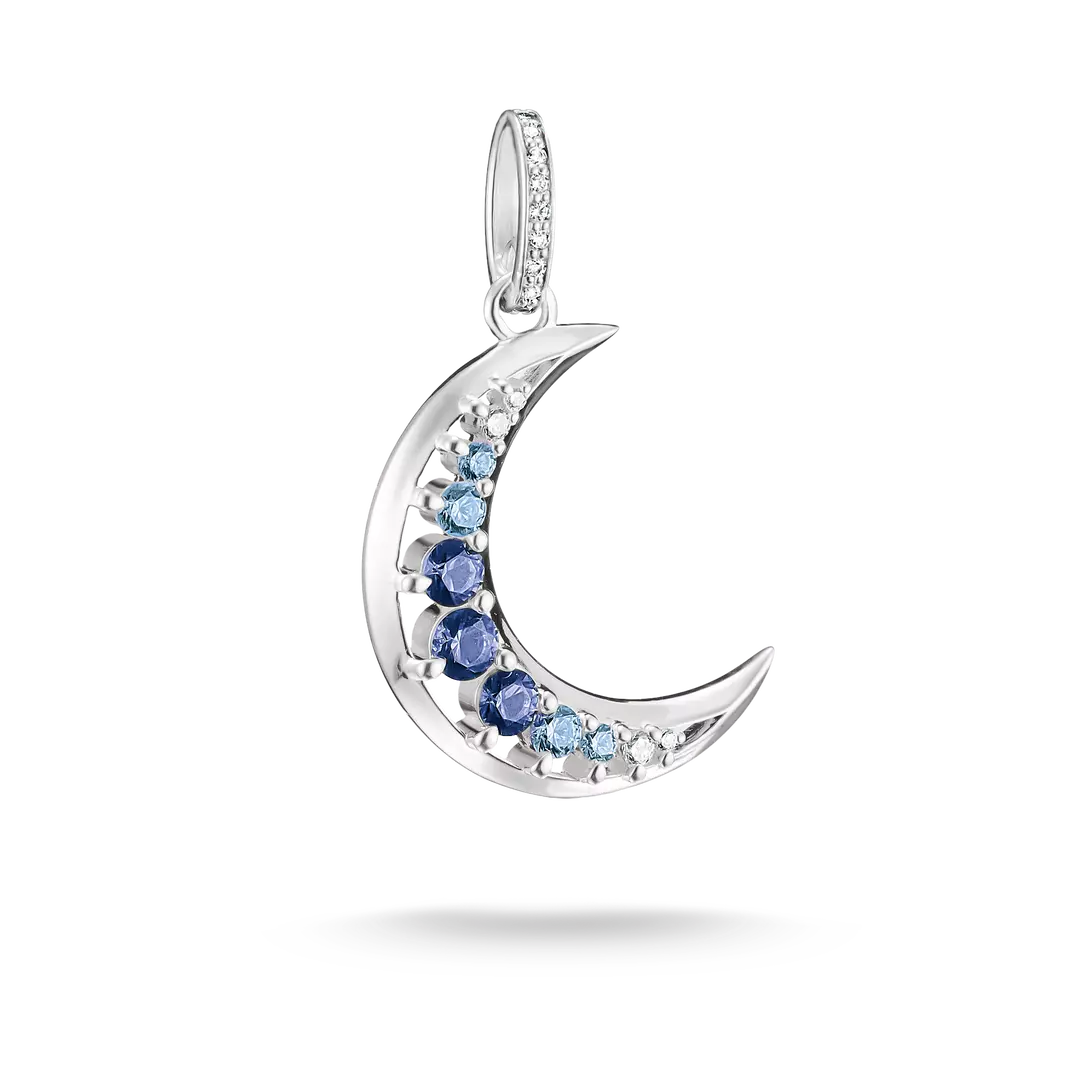 A crescent moon pendant charm in silver-tone metal, decorated with a row of round blue and light blue gemstones and a border of small clear stones, shown on a white background with a soft shadow.