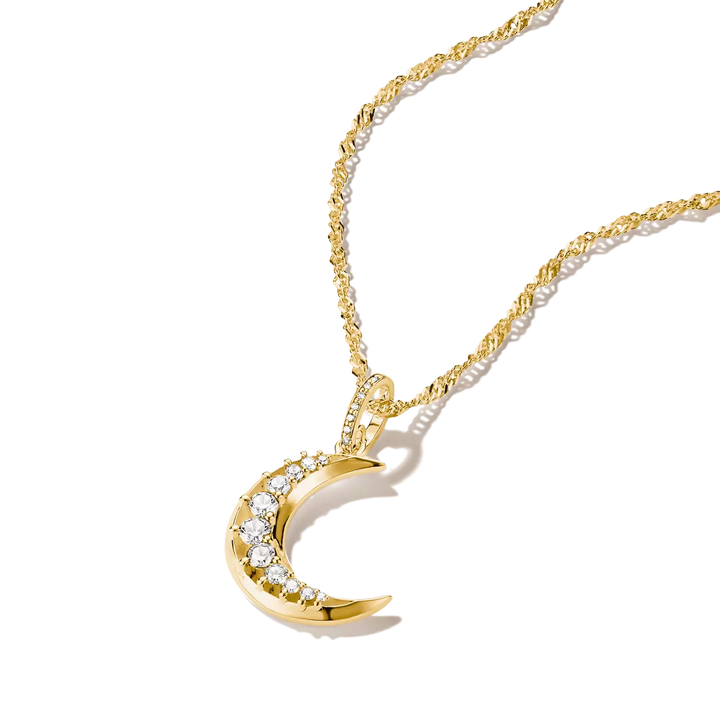 A gold crescent moon pendant necklace adorned with clear crystals, shown on a clean white background with a soft shadow.