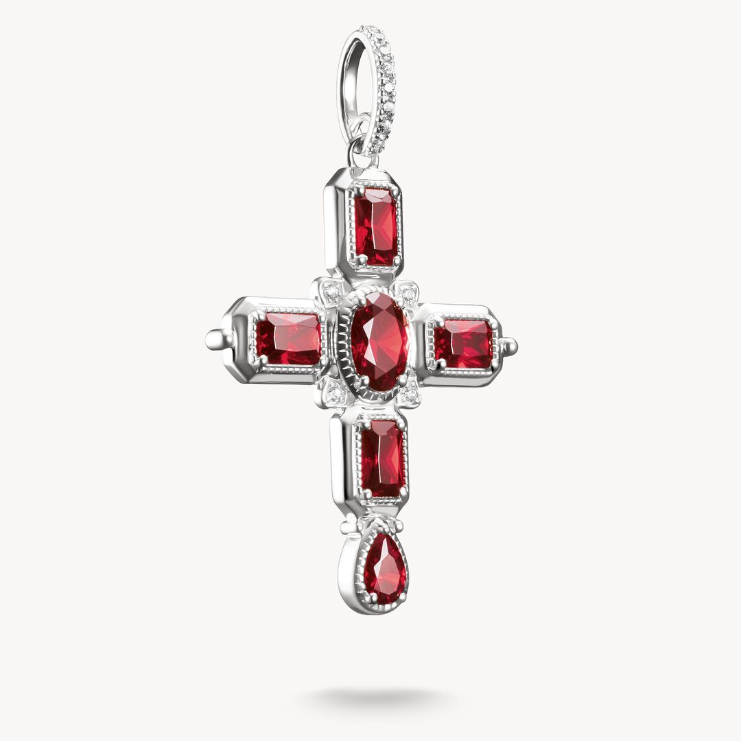Silver cross pendant with red gemstones on a white background