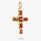 Gold cross pendant with red gemstones on a white background