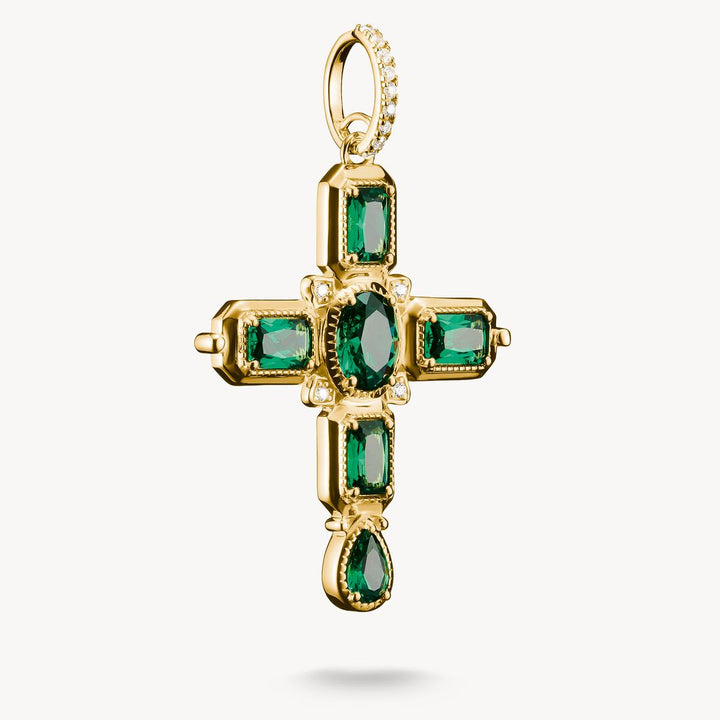 Gold cross pendant with green gemstones on a white background