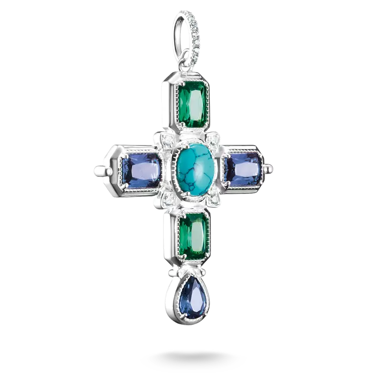 A silver cross pendant featuring a central oval turquoise-blue gemstone, surrounded by rectangular green and blue gemstones, with a teardrop-shaped blue gemstone at the bottom, set against a plain white background.