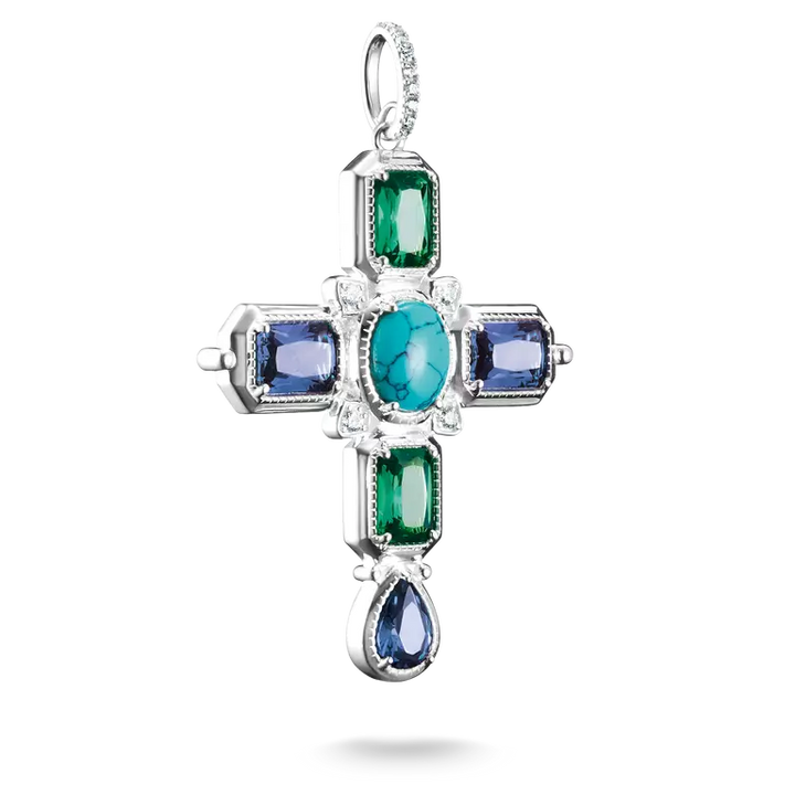 A silver cross pendant featuring a central oval turquoise-blue gemstone, surrounded by rectangular green and blue gemstones, with a teardrop-shaped blue gemstone at the bottom, set against a plain white background.
