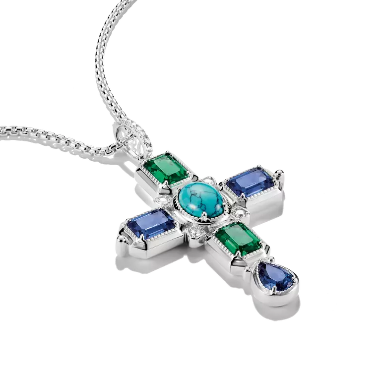A sterling silver cross pendant necklace featuring a central round turquoise gemstone surrounded by emerald-cut green and rectangular blue gemstones, with a teardrop-shaped blue gemstone at the bottom, shown on a white background.