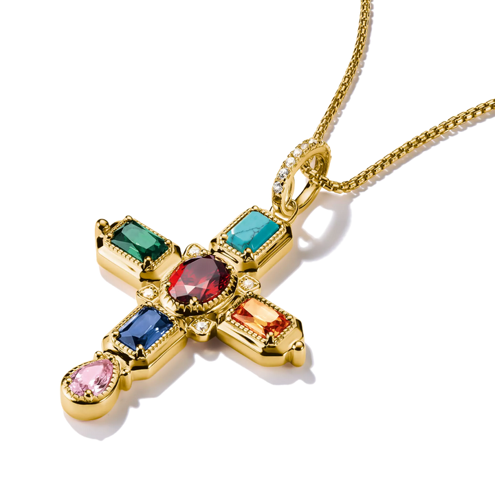 A gold cross pendant necklace adorned with multiple colorful gemstones, including green, blue, red, orange, and pink, on a white background.