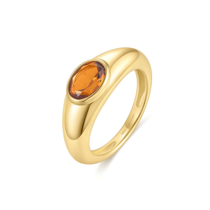 Gold ring with a brown gemstone on a white background