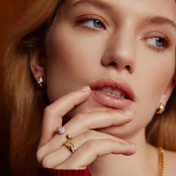 Close-up of a woman's face with jewelry on her hand