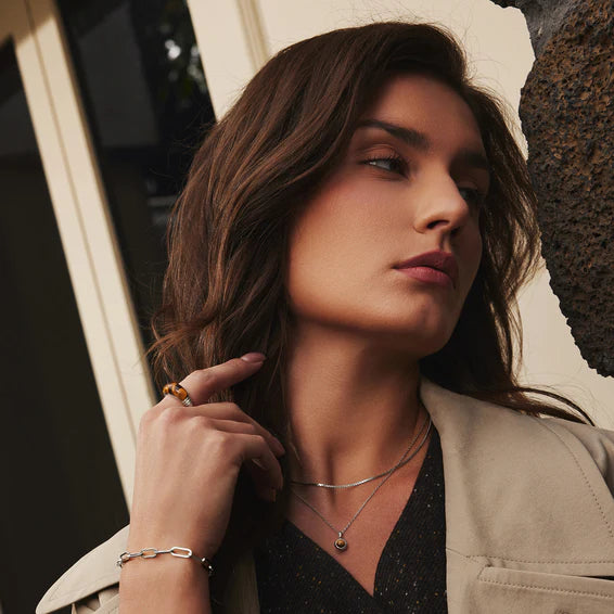 Woman wearing jewelry with a neutral background