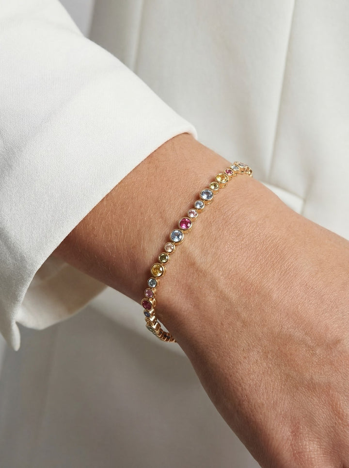 Multicolored beaded bracelet on a wrist with a white background