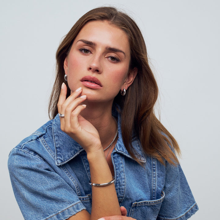 Woman wearing a denim jacket with a plain background