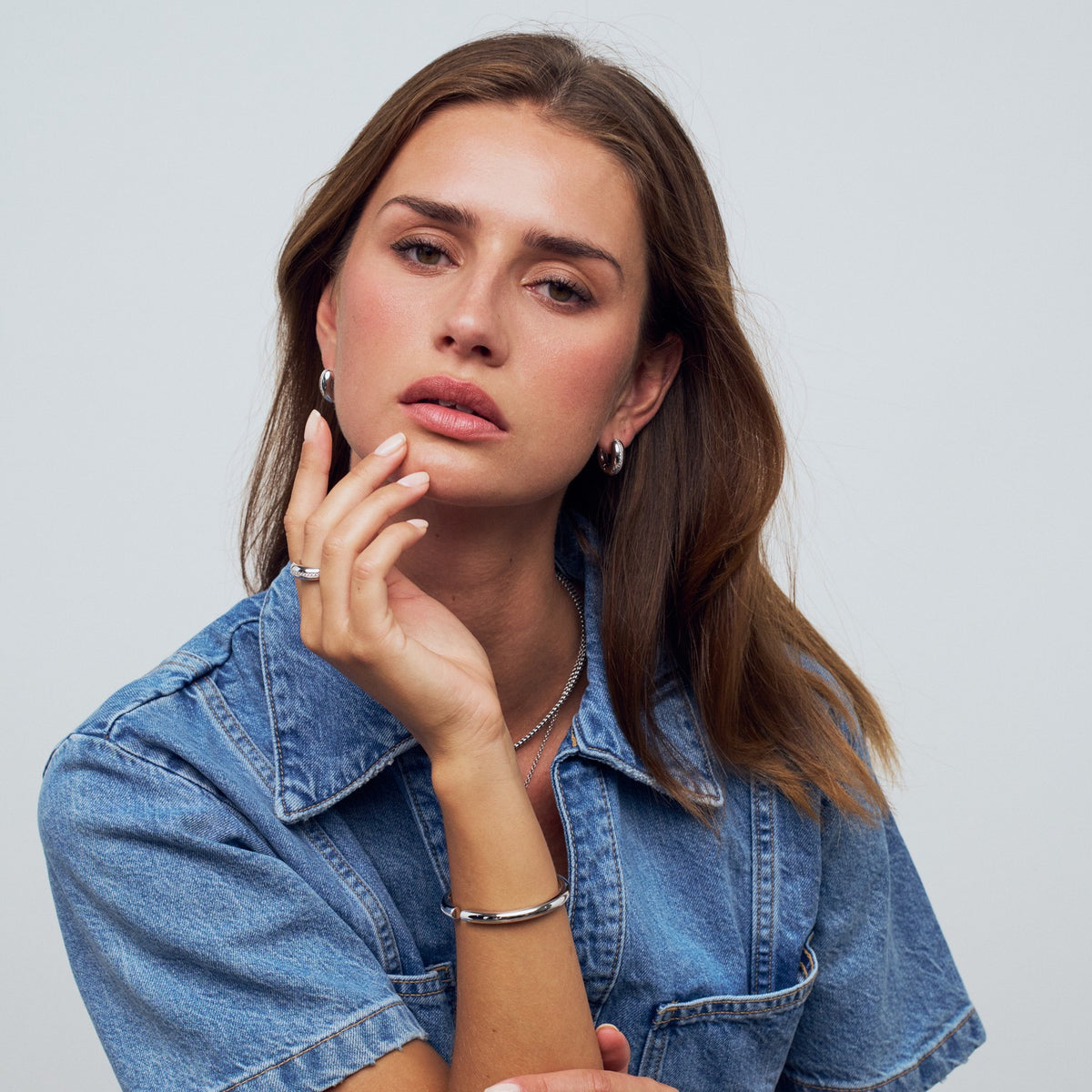 Woman wearing a denim jacket with a plain background