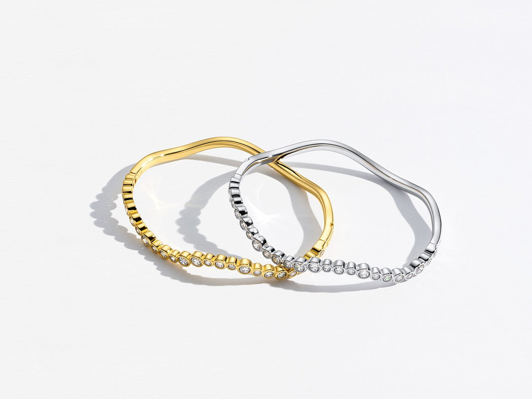 Two hoop earrings, one gold and one silver, on a light gray background