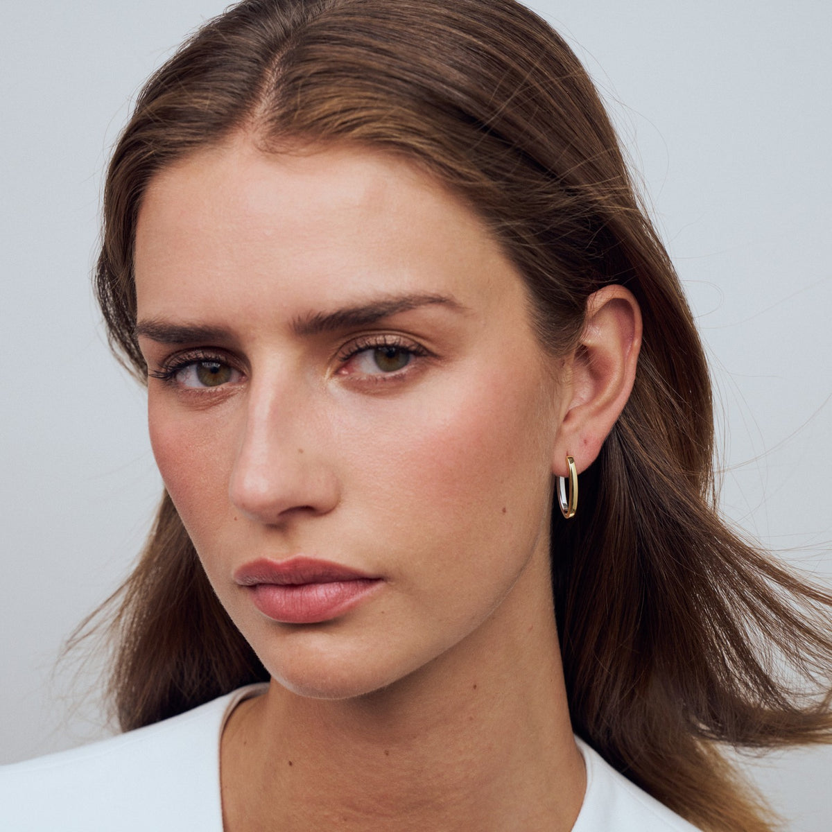 Close-up of a woman with a neutral expression against a light gray background