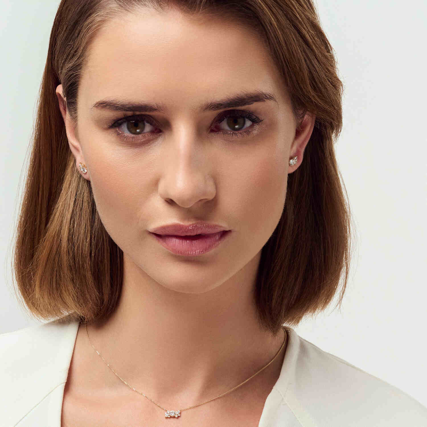 Fashionable model elegantly displaying the 14k Yellow Gold Lovere Diamond Earrings SJ-E2550-WD-YG, complemented by a matching necklace, exuding luxury.