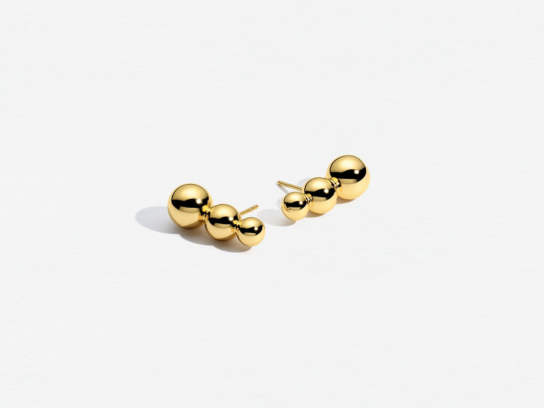 Pair of gold ball earrings on a white background