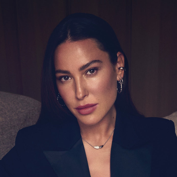 Woman wearing a dark blazer with a blurred background