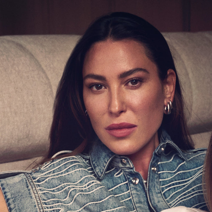 Woman wearing a denim jacket sitting on a couch