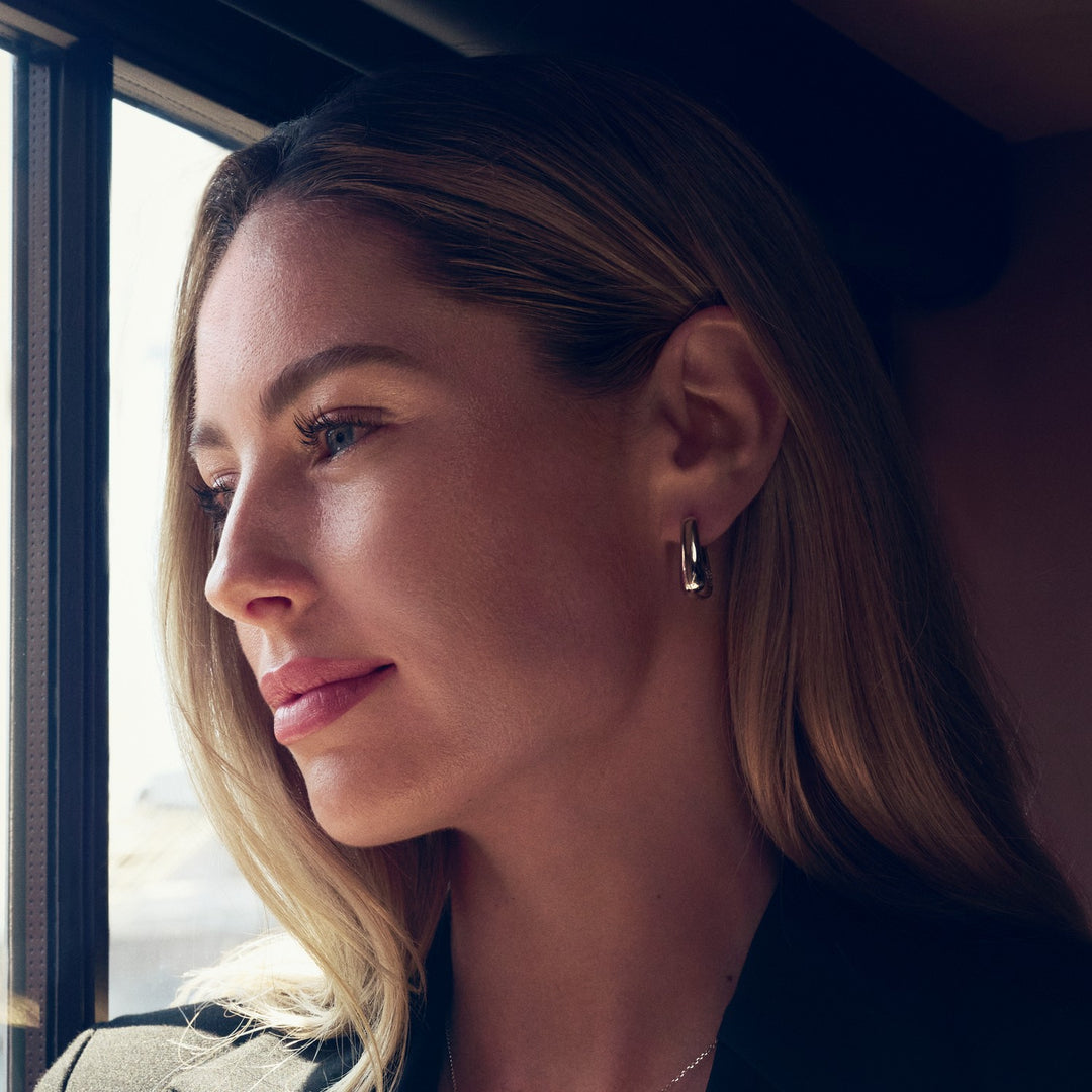 Woman looking out a window with a blurred background
