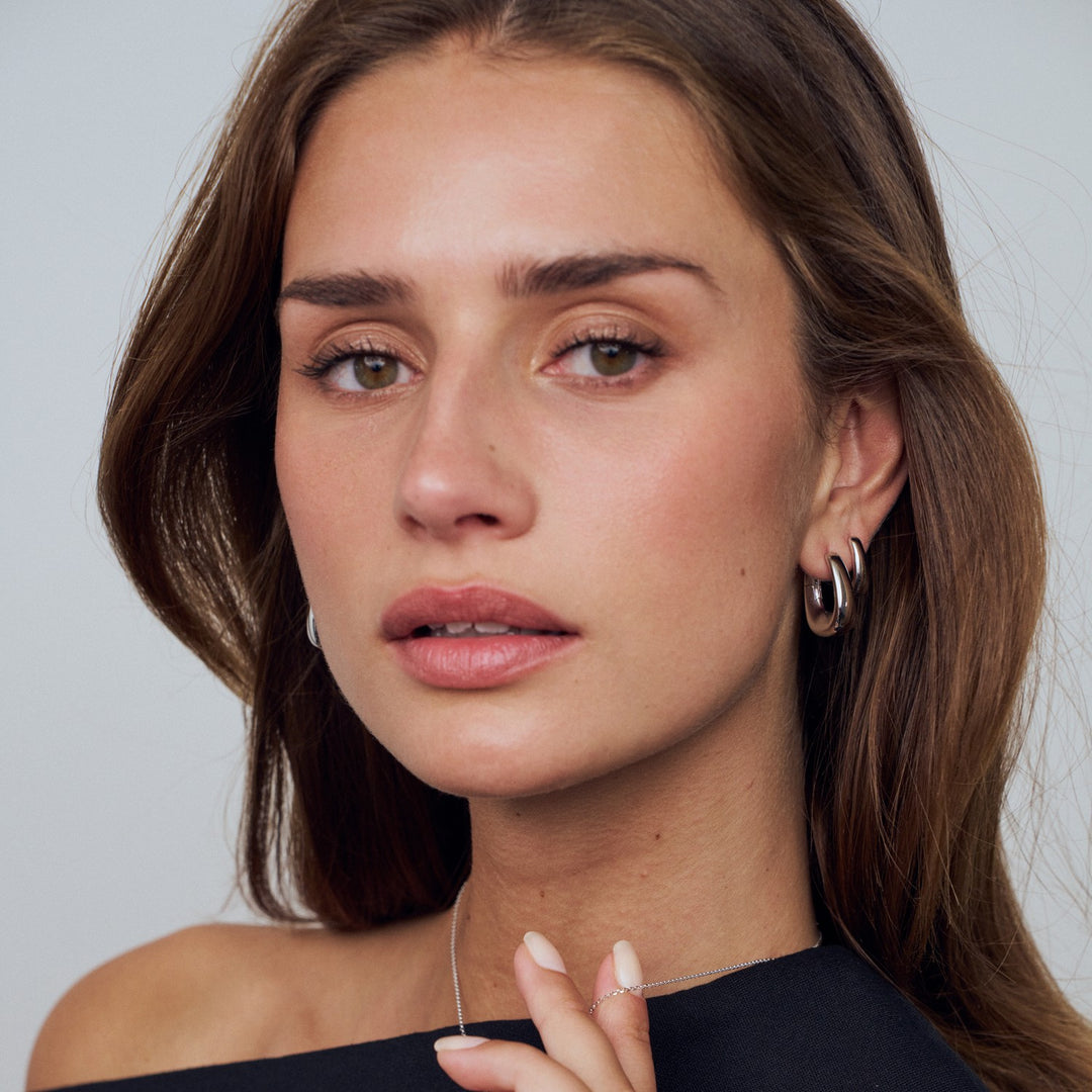 Close-up of a woman with a neutral expression against a plain background