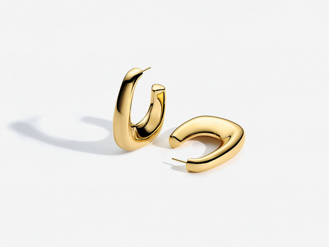 Gold hoop earrings on a light gray background