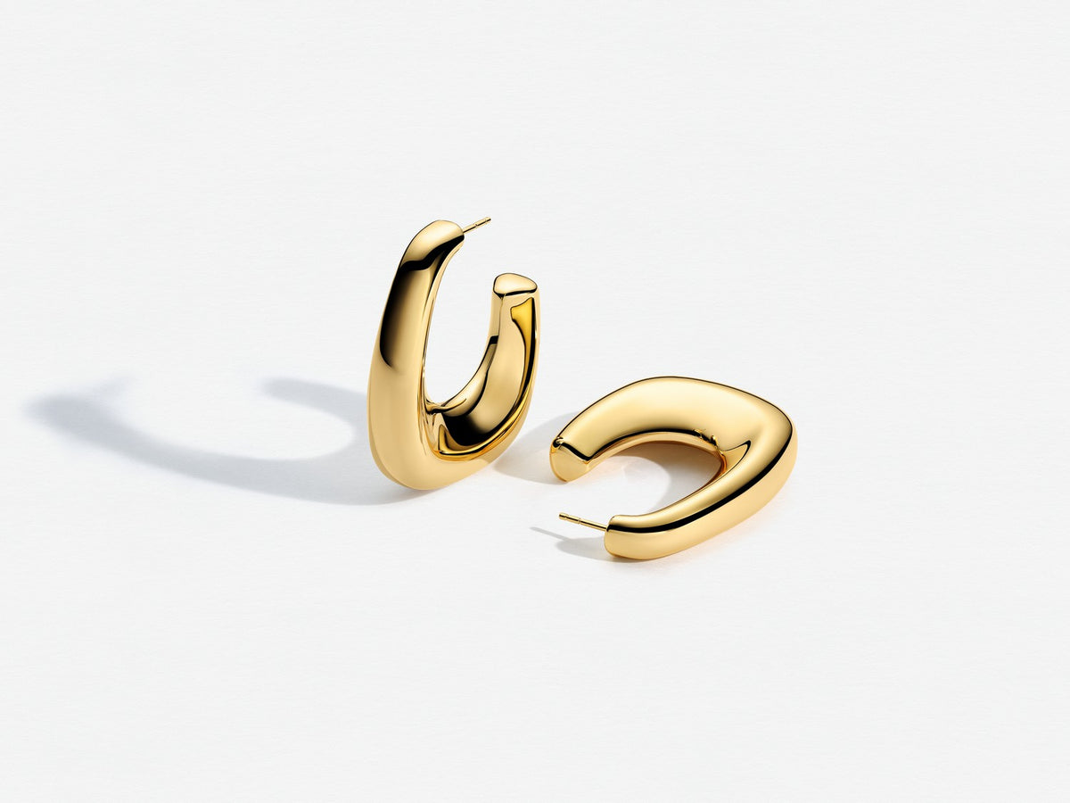 Gold hoop earrings on a light gray background