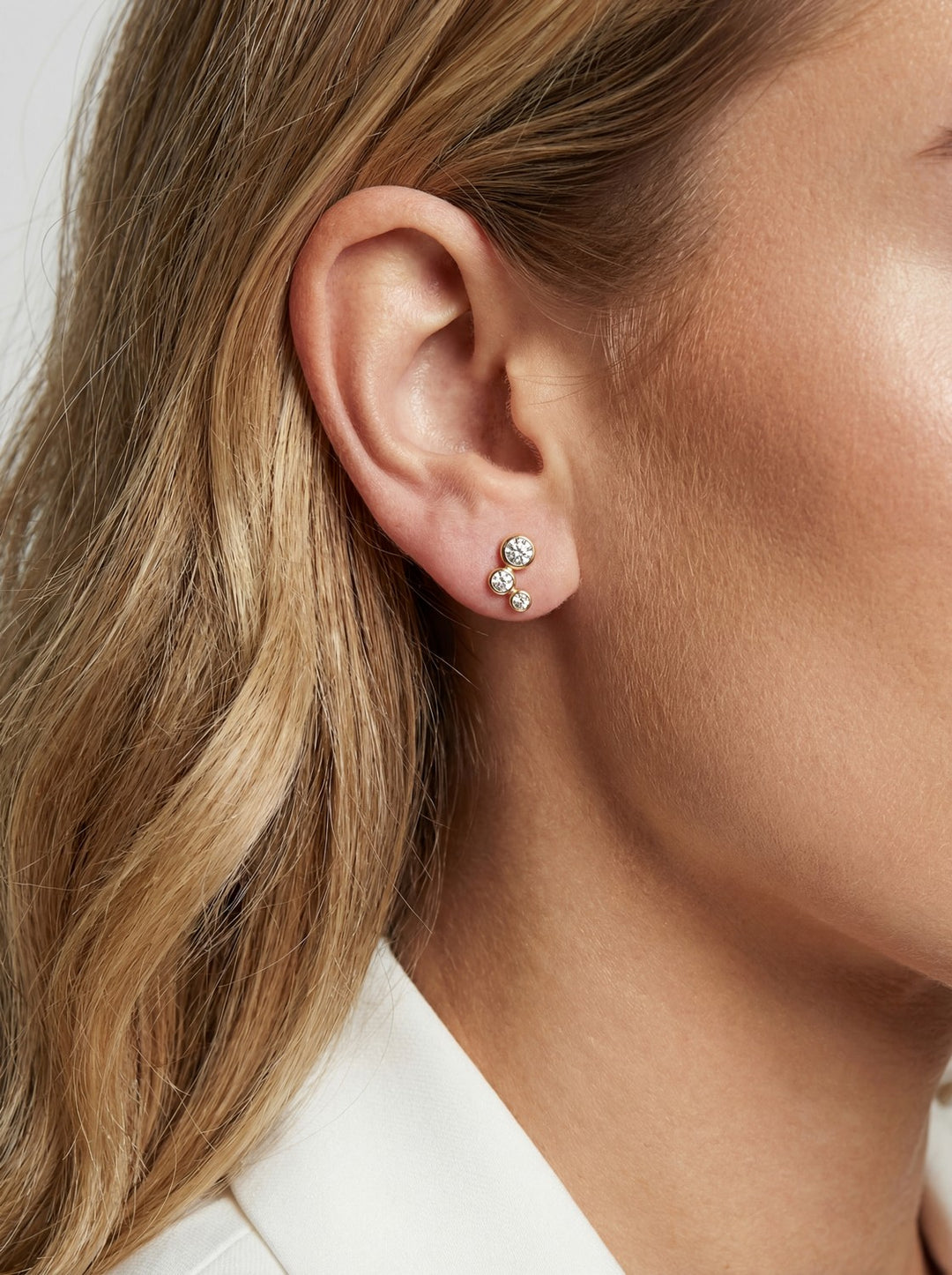 Close-up of an ear wearing a small earring with a blurred background