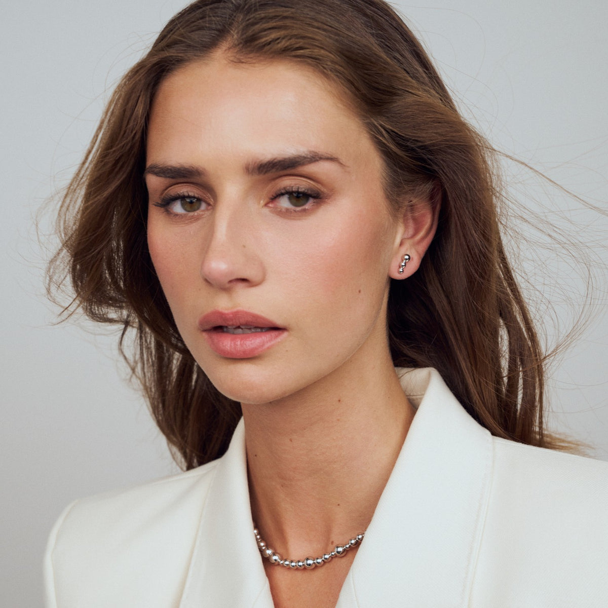 Woman wearing a white blazer with a plain background