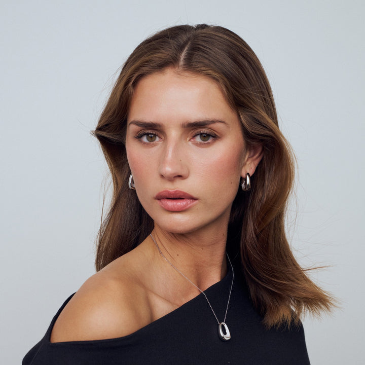 Woman wearing a black top with a plain background