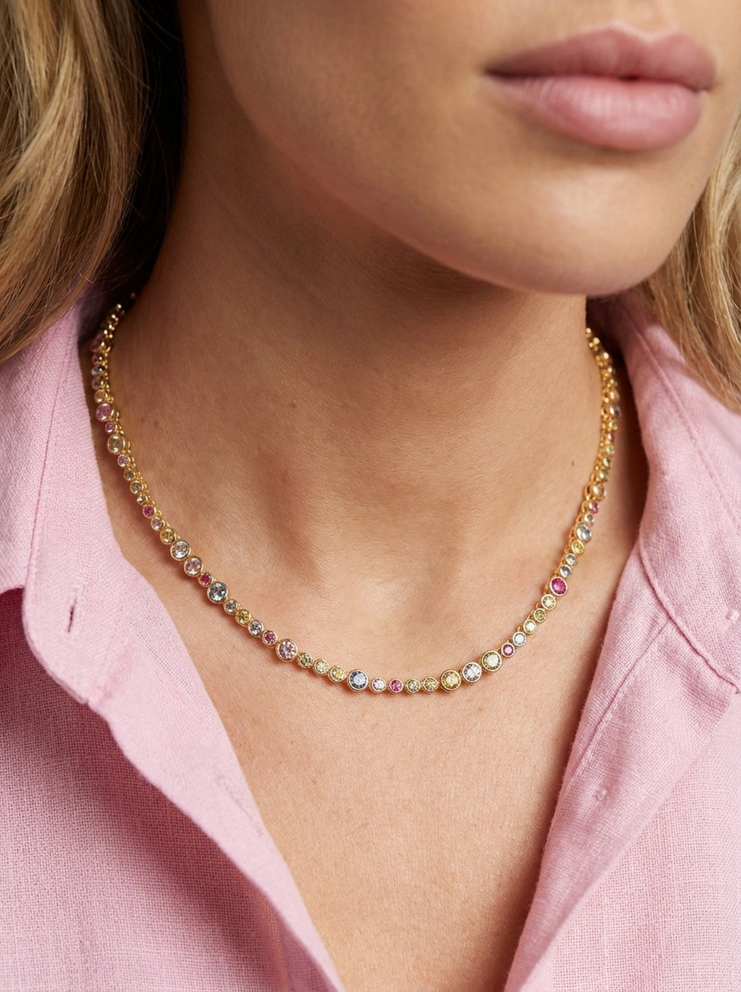 Close-up of a person wearing a colorful beaded necklace with a pink shirt.