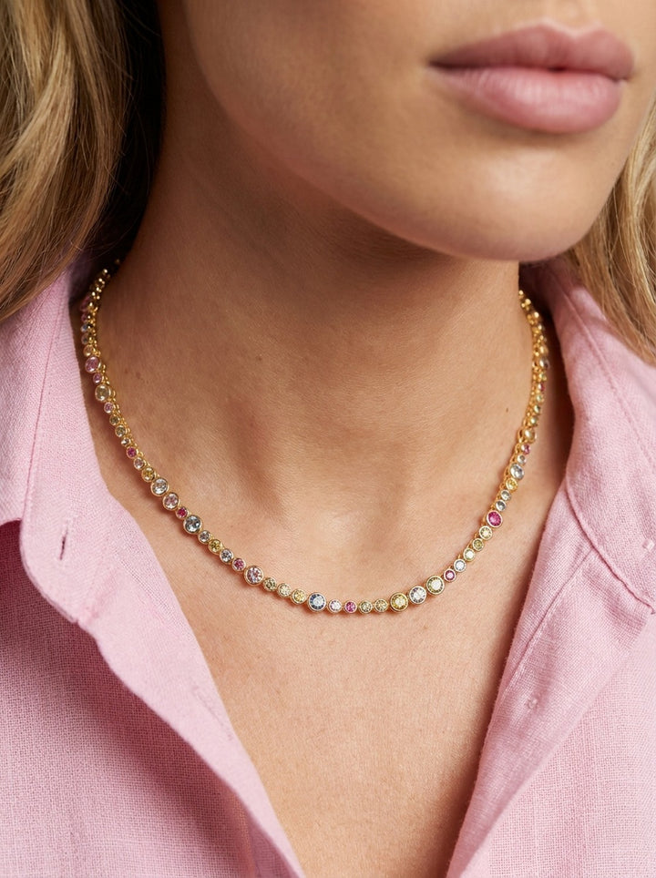 Close-up of a person wearing a colorful beaded necklace with a pink shirt.