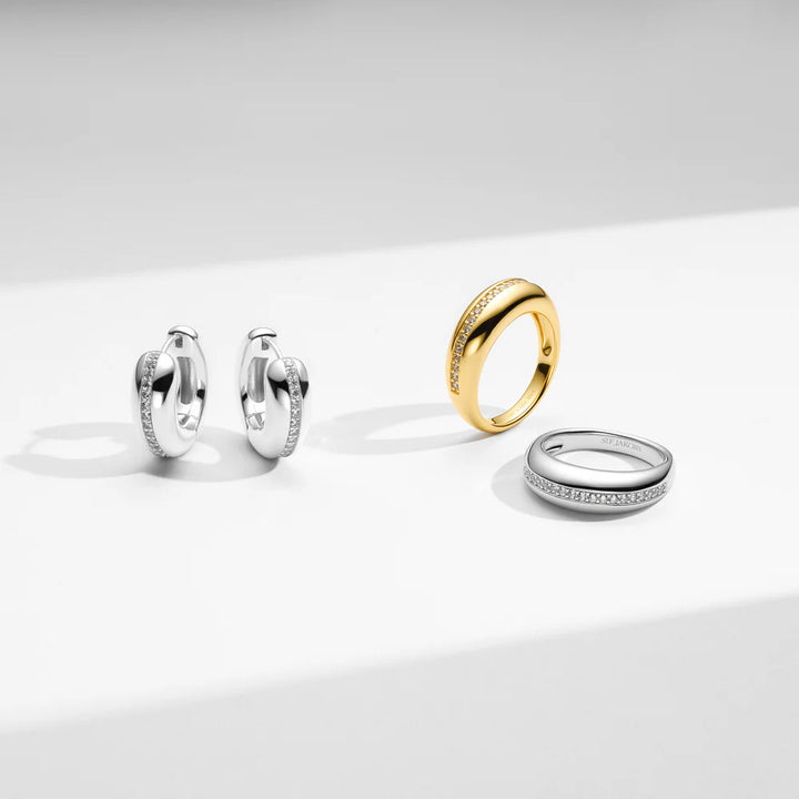 Three rings in gold, silver, and white on a light gray background