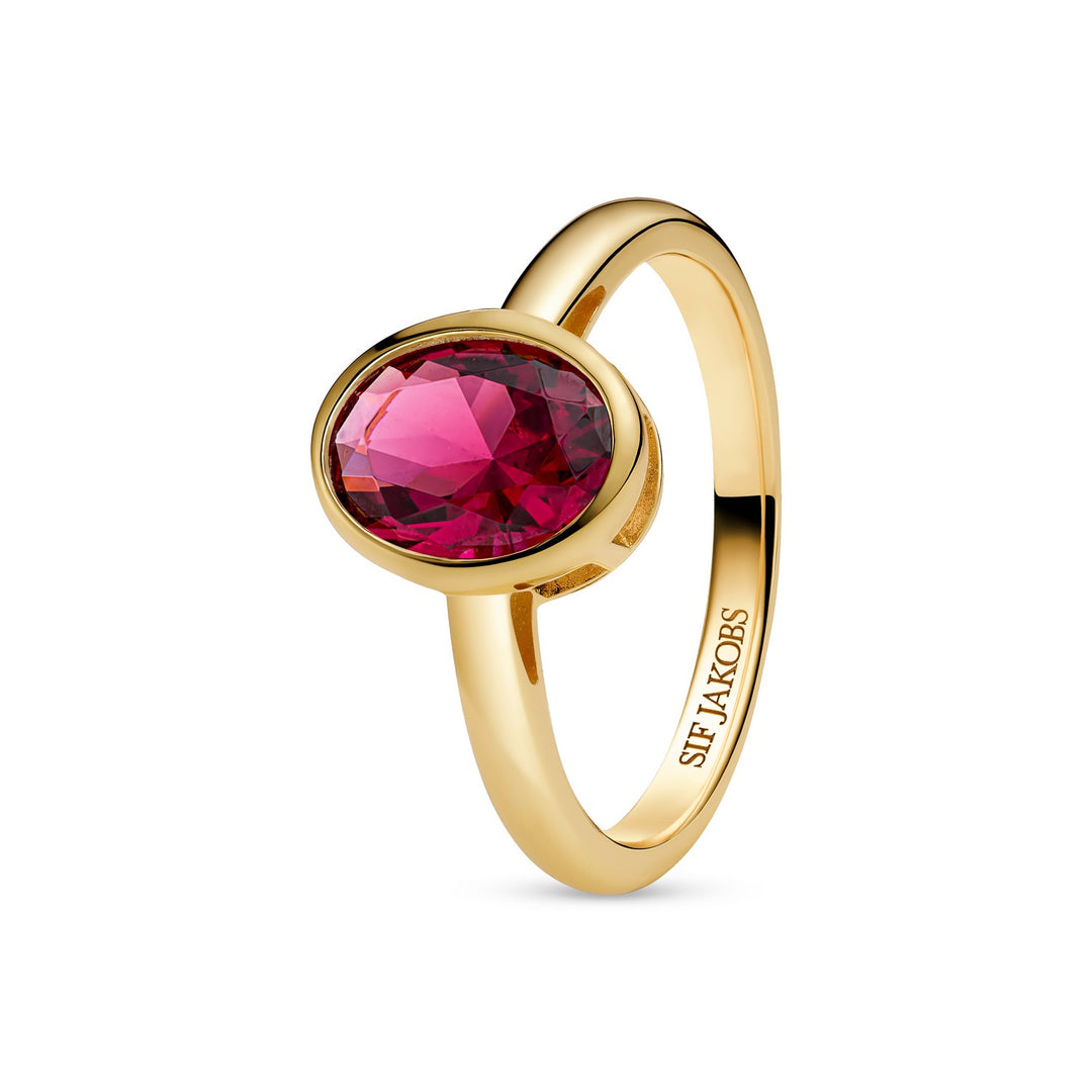 Gold ring with a red gemstone on a white background