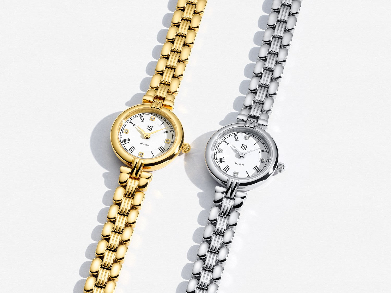 Two watches, one gold and one silver, on a light background