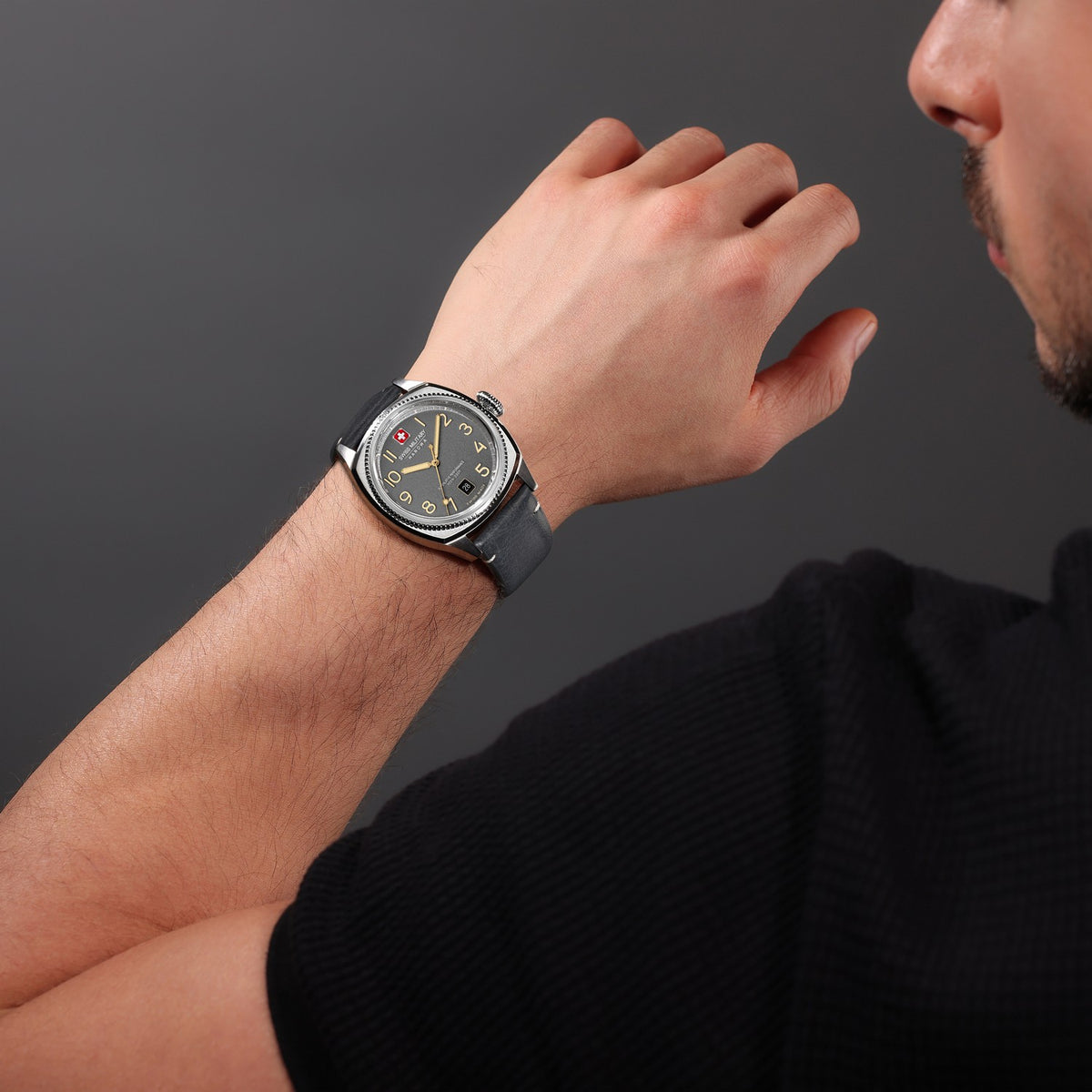 Man wearing a wristwatch on a dark background