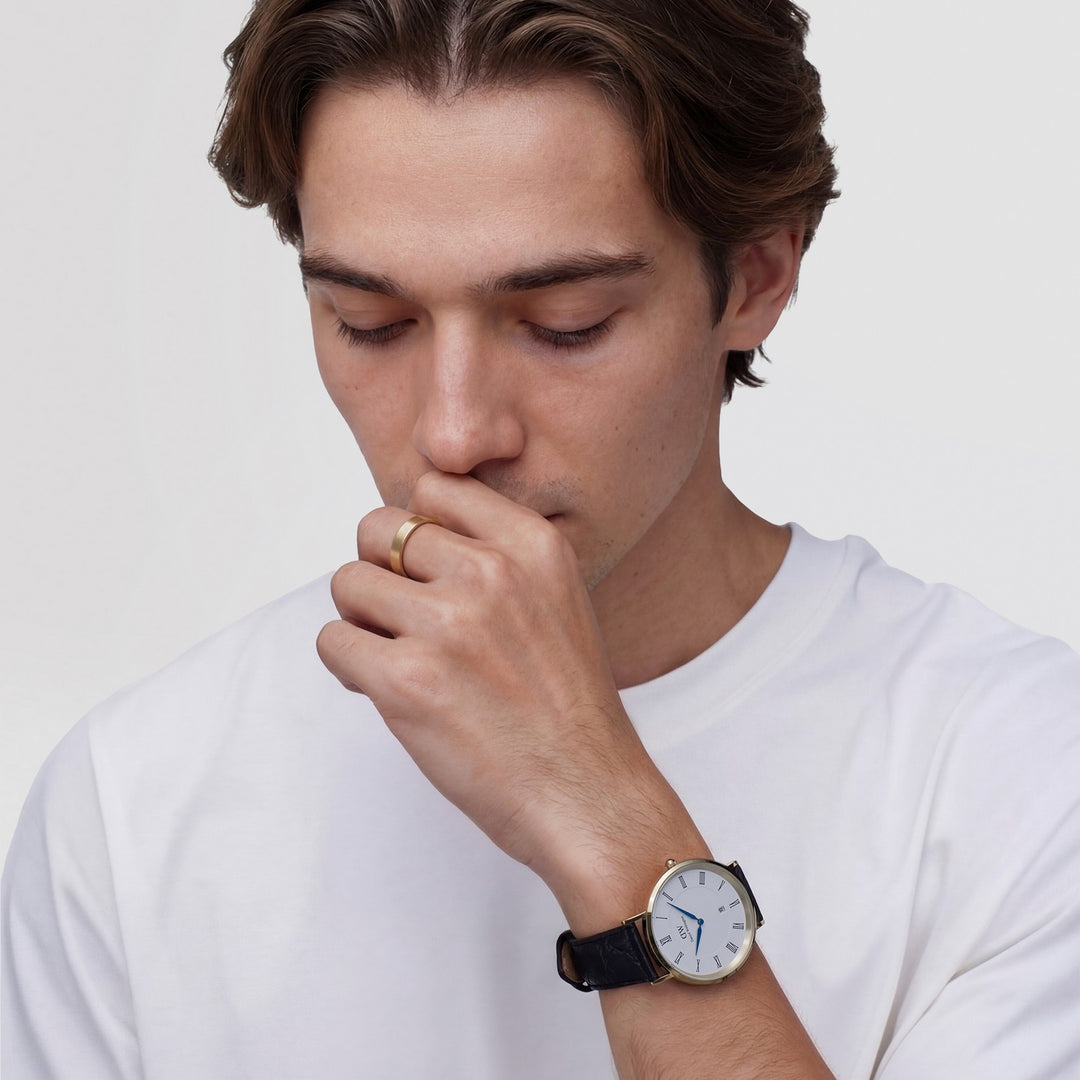 Man wearing a white t-shirt and a watch, looking down.