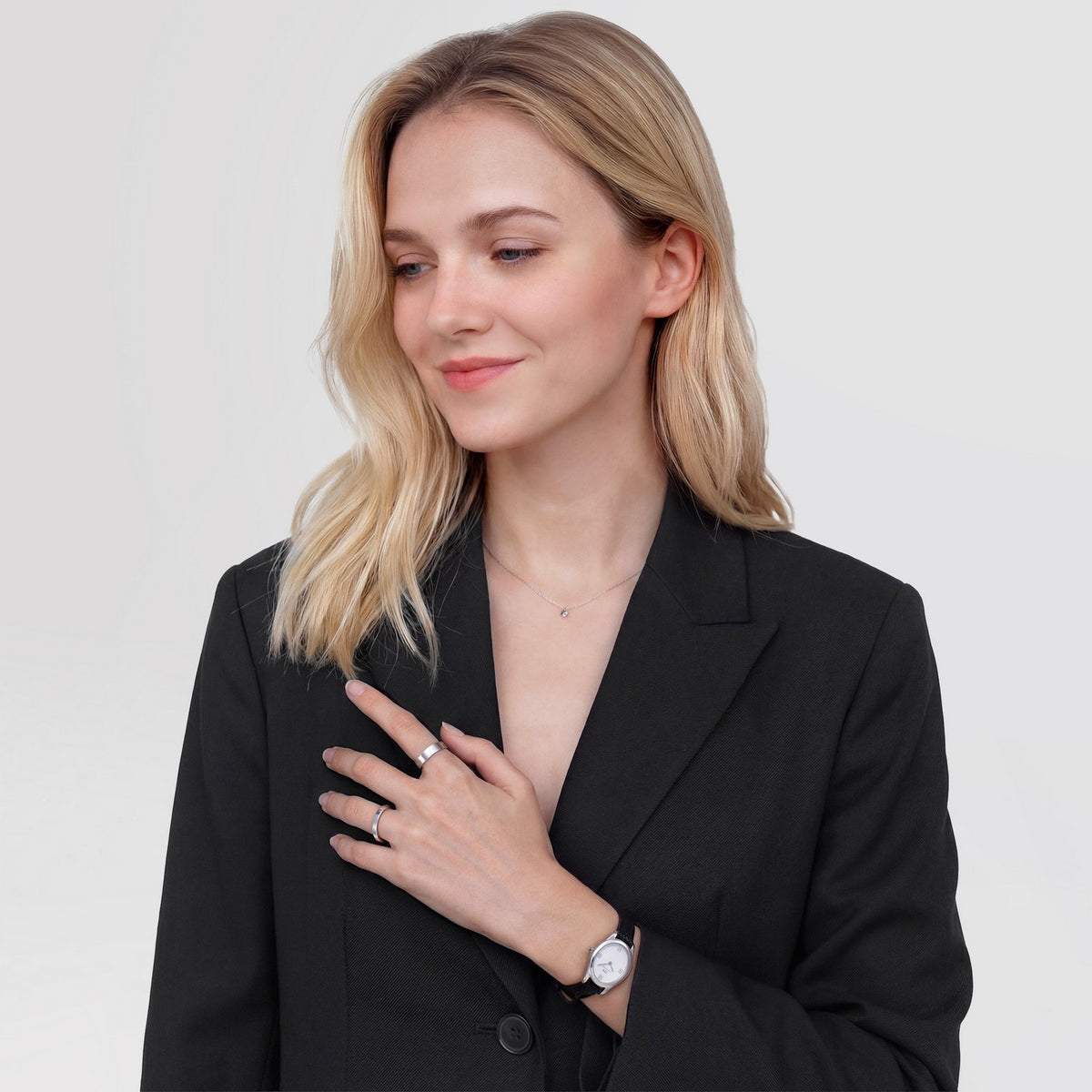 Woman wearing a black blazer with a plain background