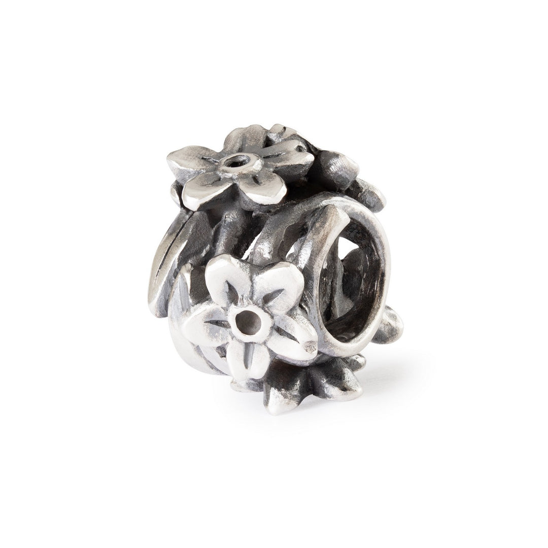 Silver floral charm bead on a white background