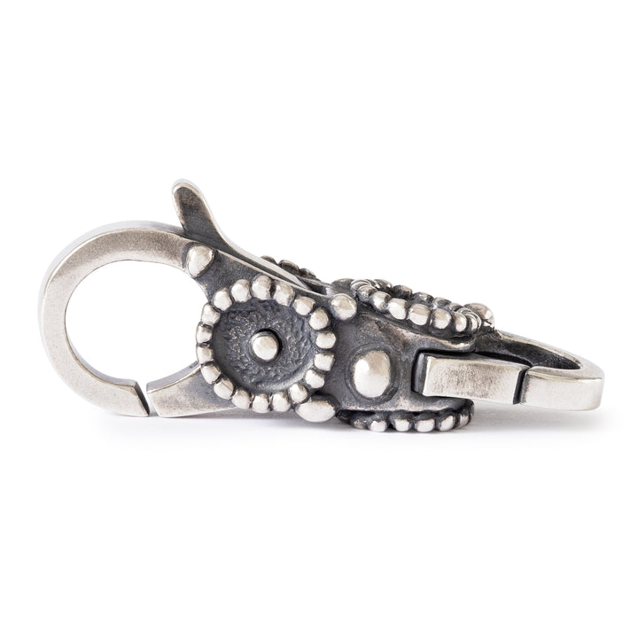 Silver keychain with intricate design on a white background